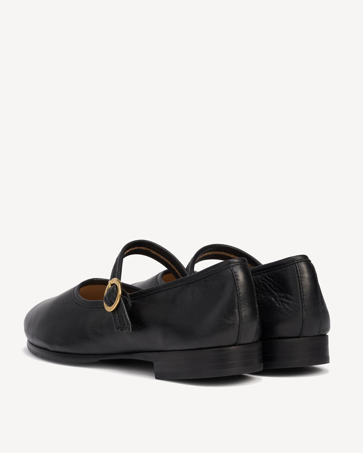 Back angle view of a pair of Mary Jane flats. The Modern-Day Mary Jane Blackout. Sizes 5–12.