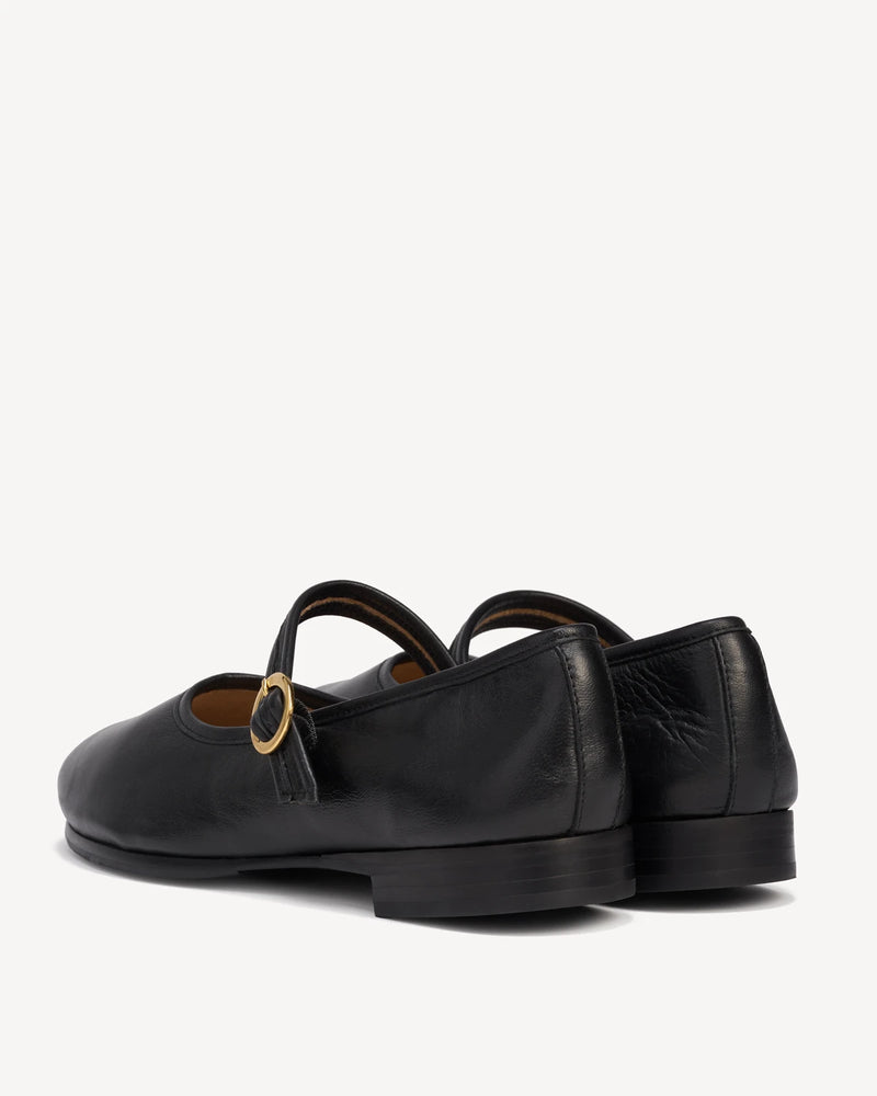 Back angle view of a pair of Mary Jane flats. The Modern-Day Mary Jane Blackout. Sizes 5–12.
