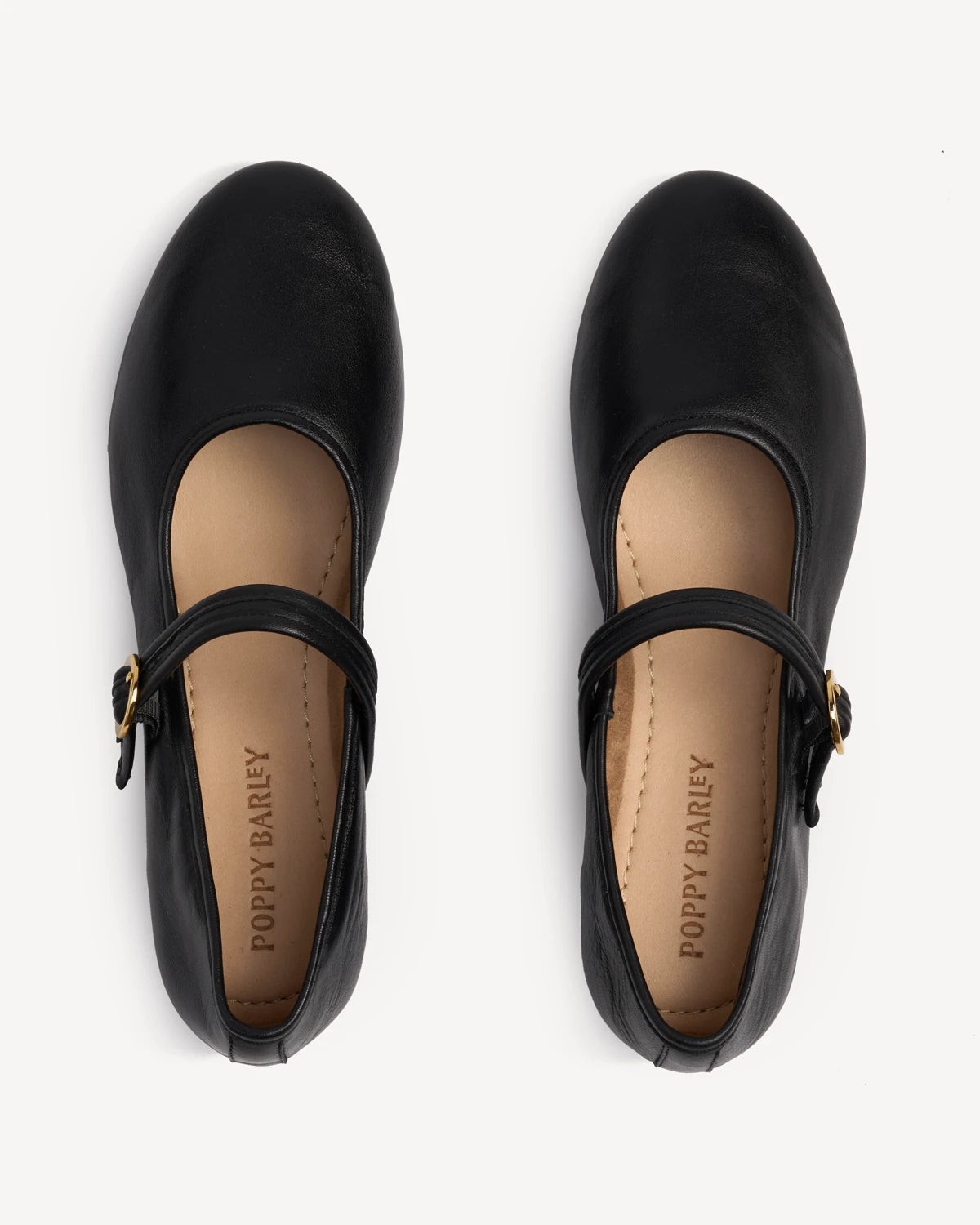 Overhead view of a pair of Mary Jane flats with buckled straps. The Modern-Day Mary Jane Blackout. Sizes 5–12.