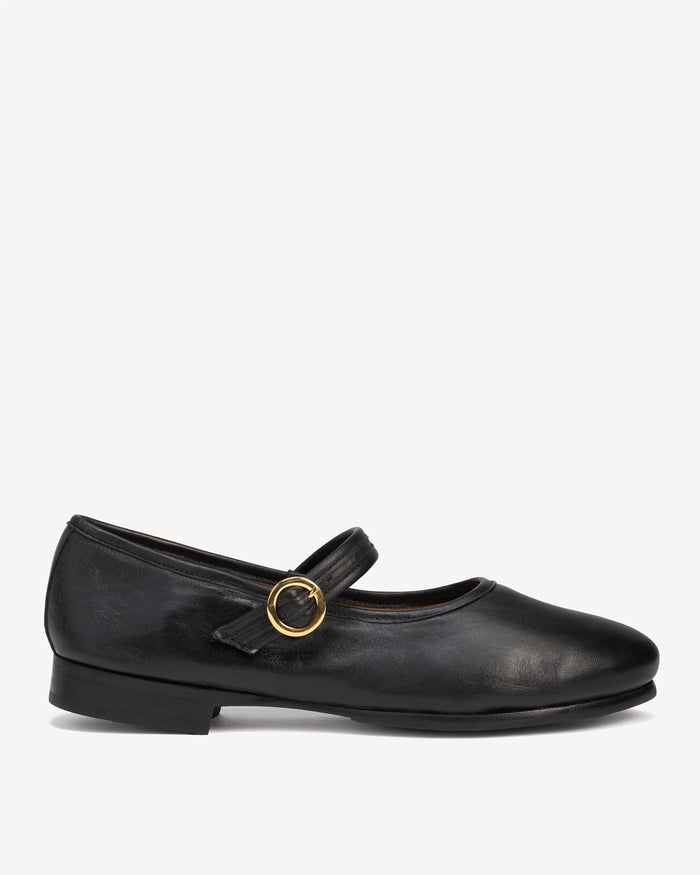 Side view of a leather Mary Jane flat with round toe and ankle strap. The Modern-Day Mary Jane Blackout. Sizes 5–12.