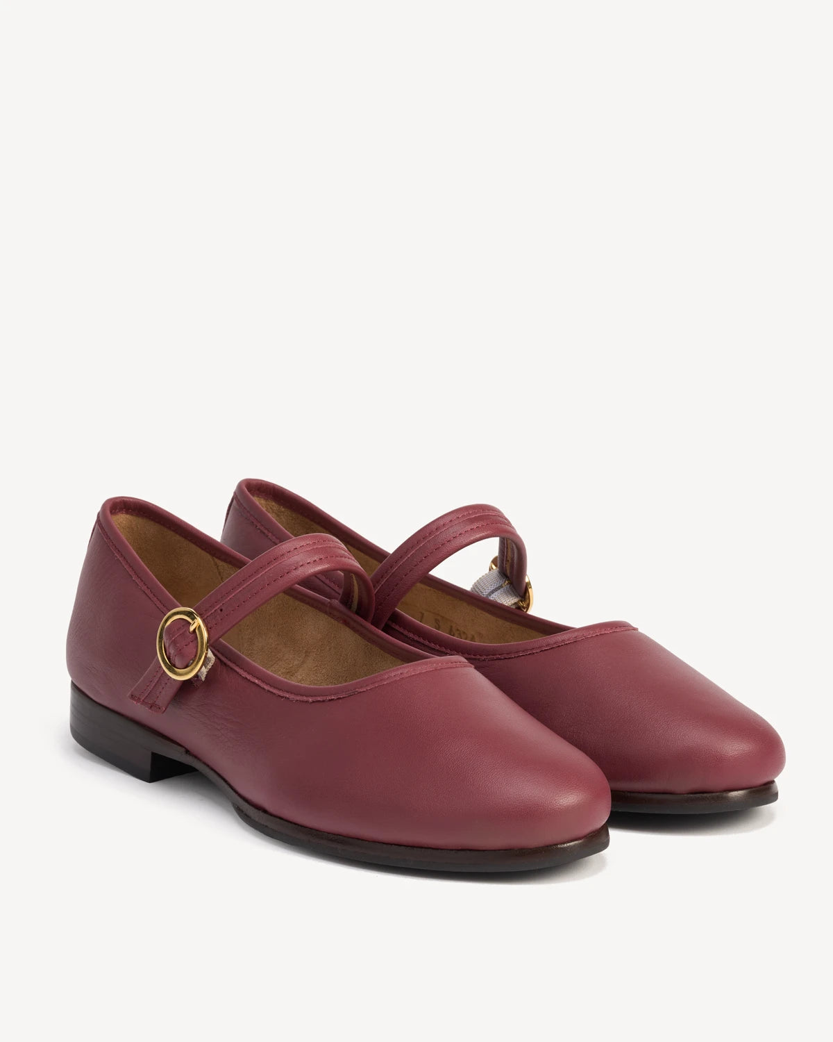 Round-toe mary jane flats with buckle straps, angled view. The Modern-Day Mary Jane Compote. Sizes 5–12, wide available.