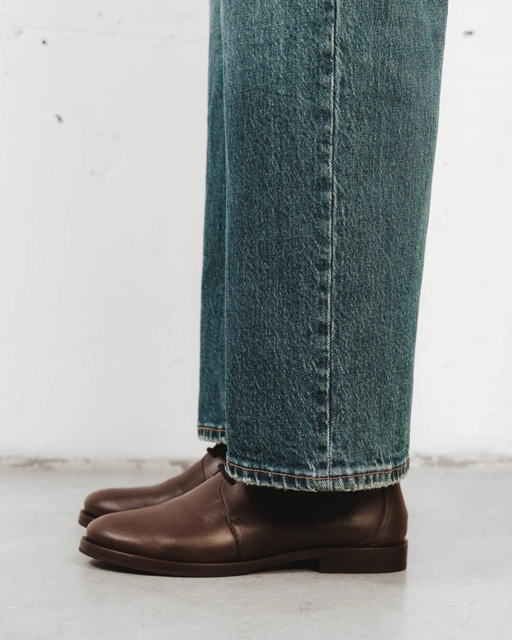 Model walking in the oxfords wearing jeans. The Capsule Oxford Cocoa Plum. Sizes 5–12, wide available.