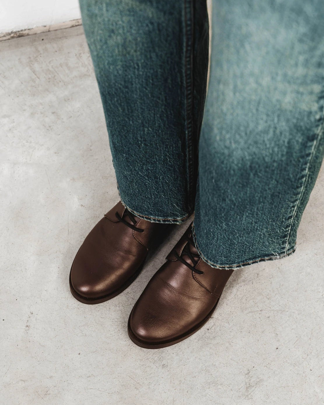 Model wearing the oxfords with straight-leg jeans. The Capsule Oxford Cocoa Plum. Sizes 5–12, wide available.