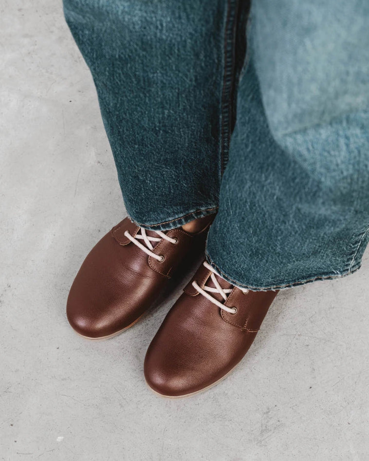 Close-up of pebbled-leather oxfords worn with cropped denim. The Eyelet Oxford 2.0 French Press. Sizes 5–12, wide available.