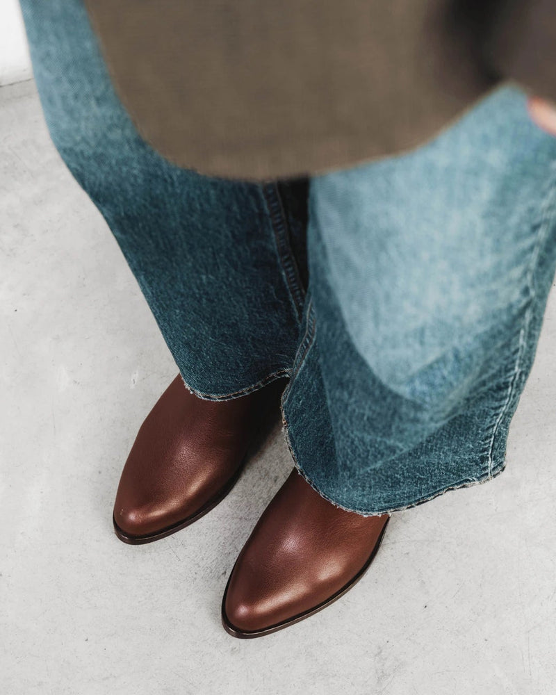 Close-up of ankle boots worn with wide-leg denim. The Two Point Five Ankle Boot French Press. Sizes 5–12, wide available.
