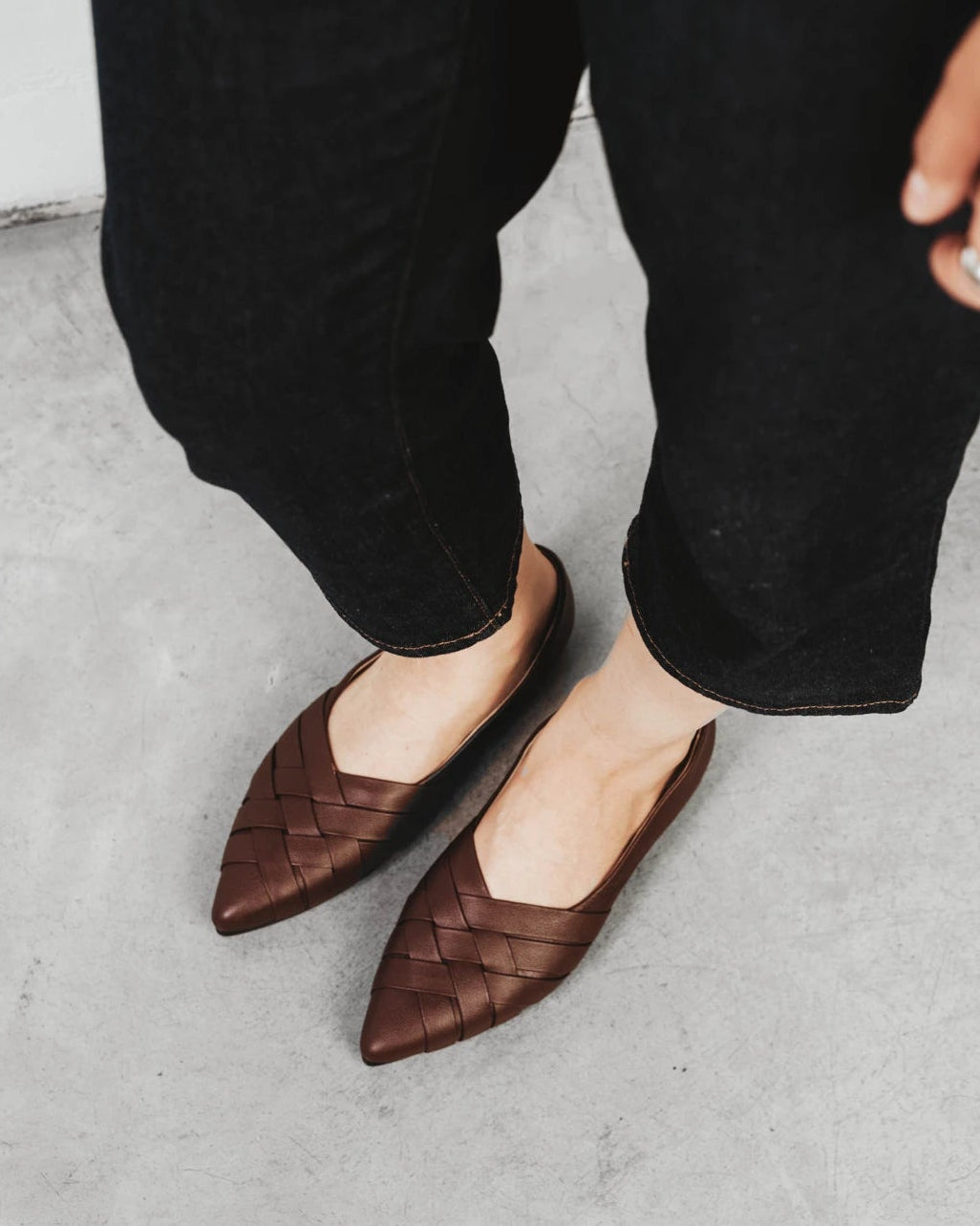 Close-up of woven leather flats worn with cropped black trousers. The Athena Flat French Press. Sizes 5–12, wide available.