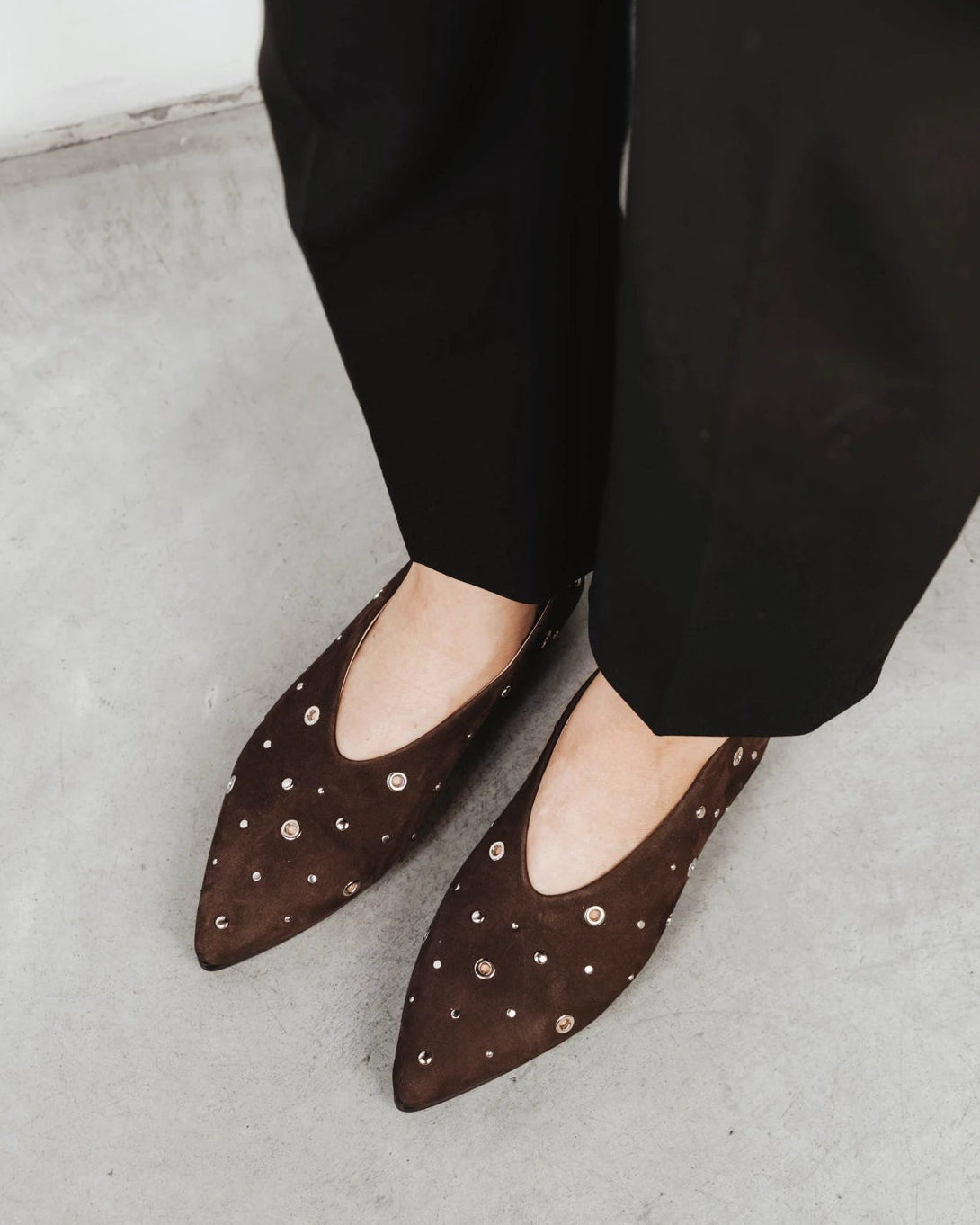Model wearing the studded flats. The Atelier Flat Cocoa Plum Studded. Sizes 5–12, wide available.