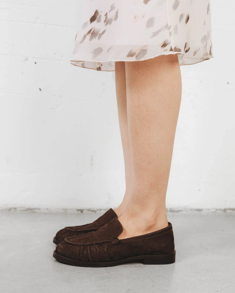 Close-up of a suede loafer worn with a printed dress. The Laid Back Loafer Cocoa Plum. Sizes 5–12, wide available.