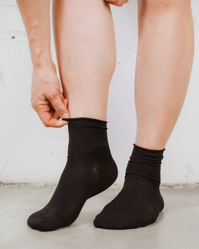 Front view of ankle-height socks with a ribbed cuff, cotton-rich knit. The Daily Mid Crew Sock Black 3-Pack.