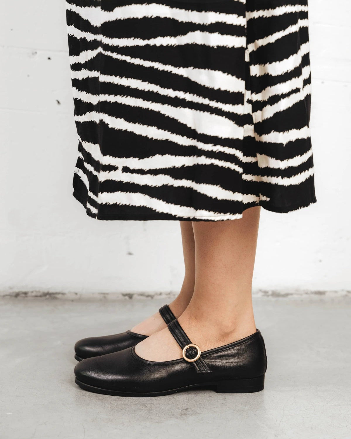 Full-length view of a model wearing the Mary Jane flats. The Modern-Day Mary Jane Blackout. Sizes 5–12.