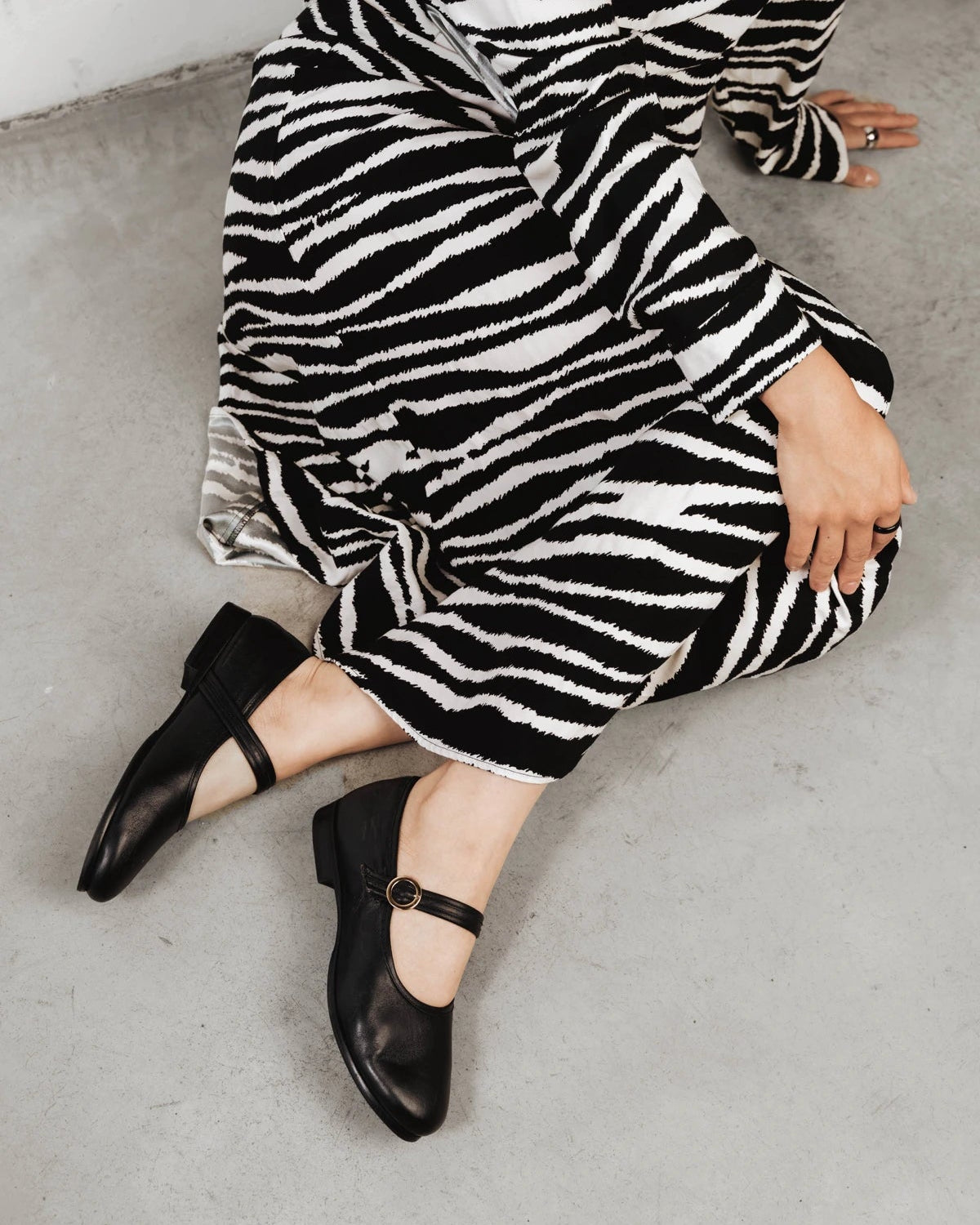 Model wearing the Mary Jane flats with a zebra-print dress. The Modern-Day Mary Jane Blackout. Sizes 5–12.