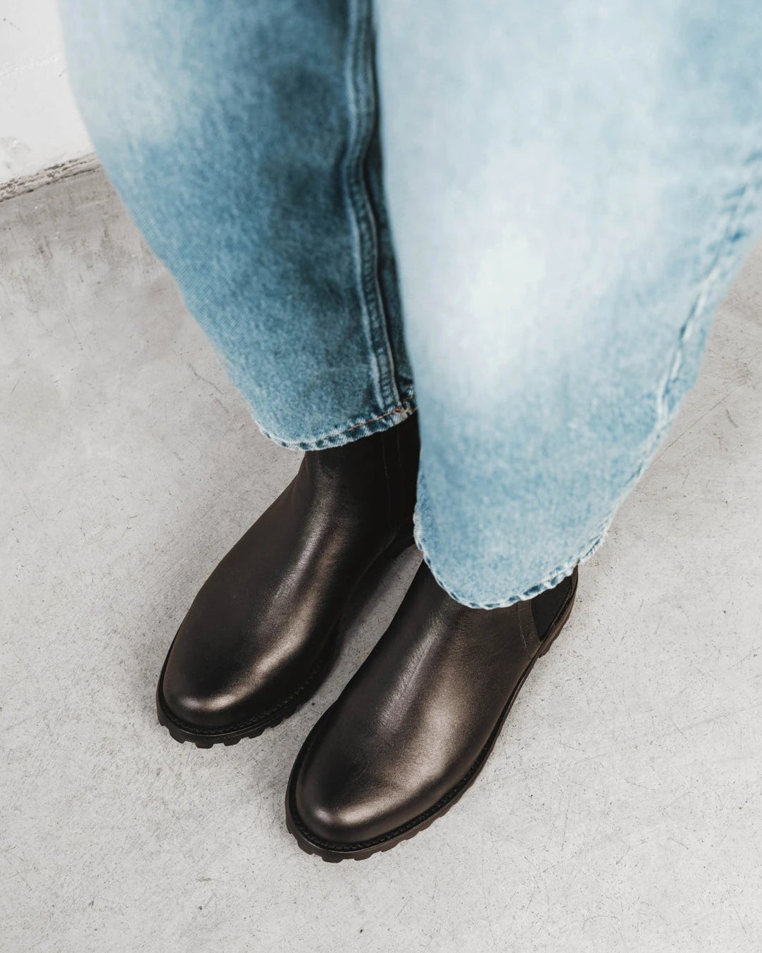 Model walking in the Chelsea boots. The On Tread Chelsea Boot Black Water Resistant. Sizes 5–12, wide available.