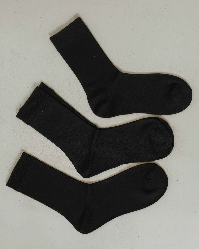 Three folded pairs laid flat, ribbed wool knit throughout. The Dressy Crew Sock Black 3-Pack.