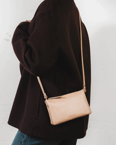 Front view of the pebbled-leather wristlet with a long crossbody strap laid flat. The 3-in-1 Wristlet Biscotti Pebble.