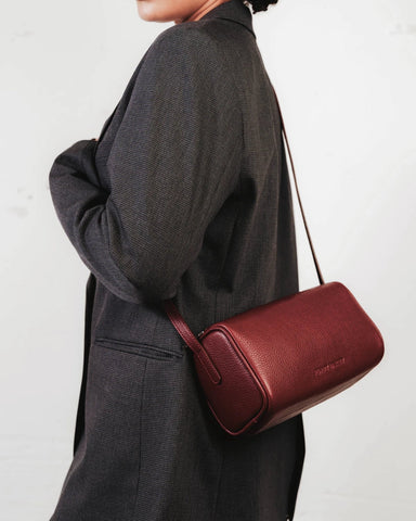 Cylindrical pebbled leather crossbody bag with a long adjustable strap. The Annex Bag Resort Red.