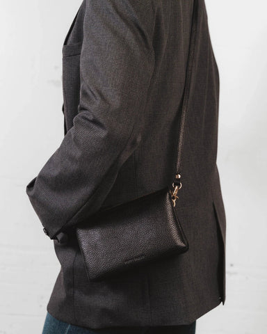 Front view of the pebbled-leather wristlet with a long crossbody strap laid flat. The 3-in-1 Wristlet Black.