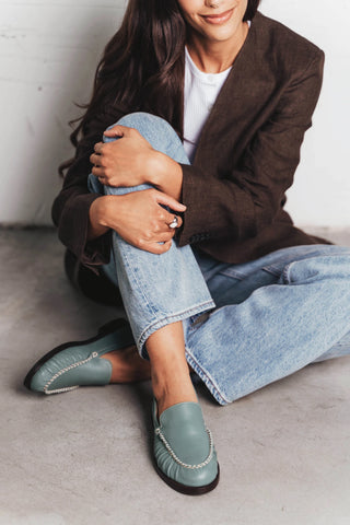Side view of slip-on loafer with ruched vamp and chain trim. The Laid Back Loafer Storm. Sizes 5–12, wide available.