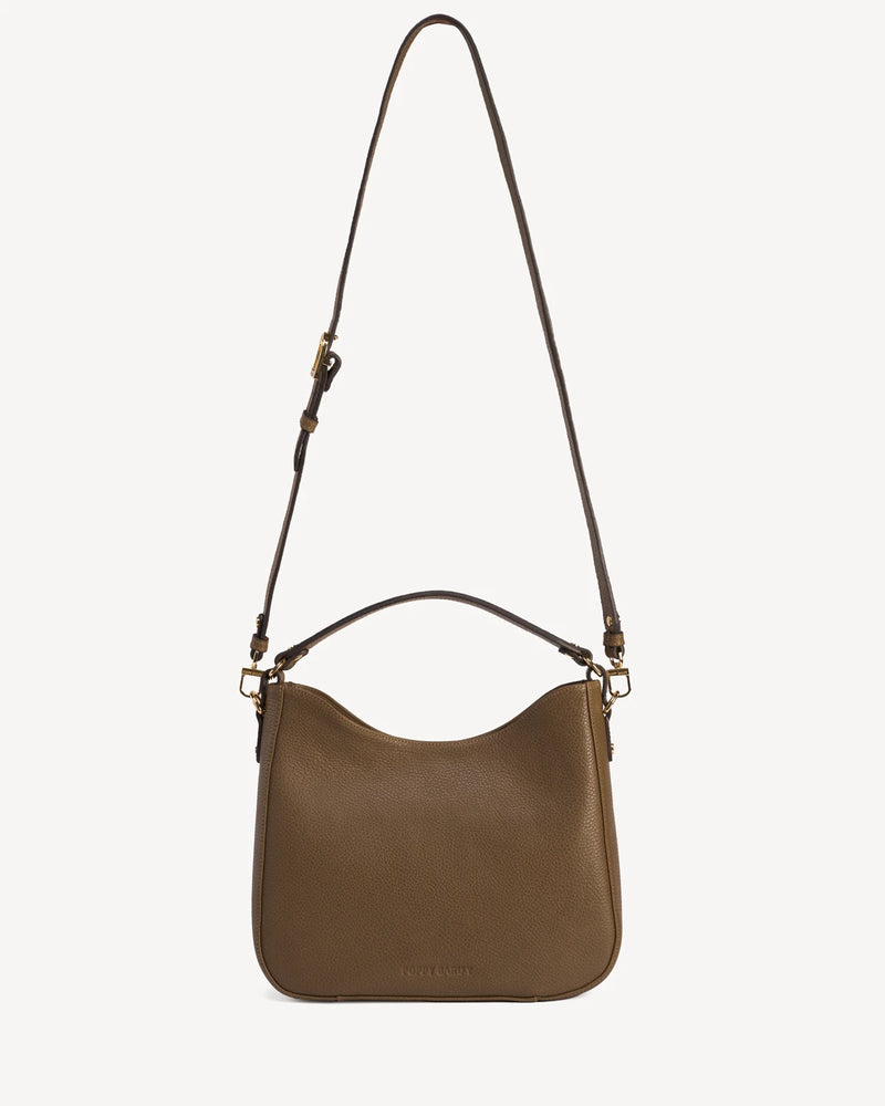 Front view of the leather hobo bag with a long adjustable strap laid flat. The Sixteenth Tote Tapenade.