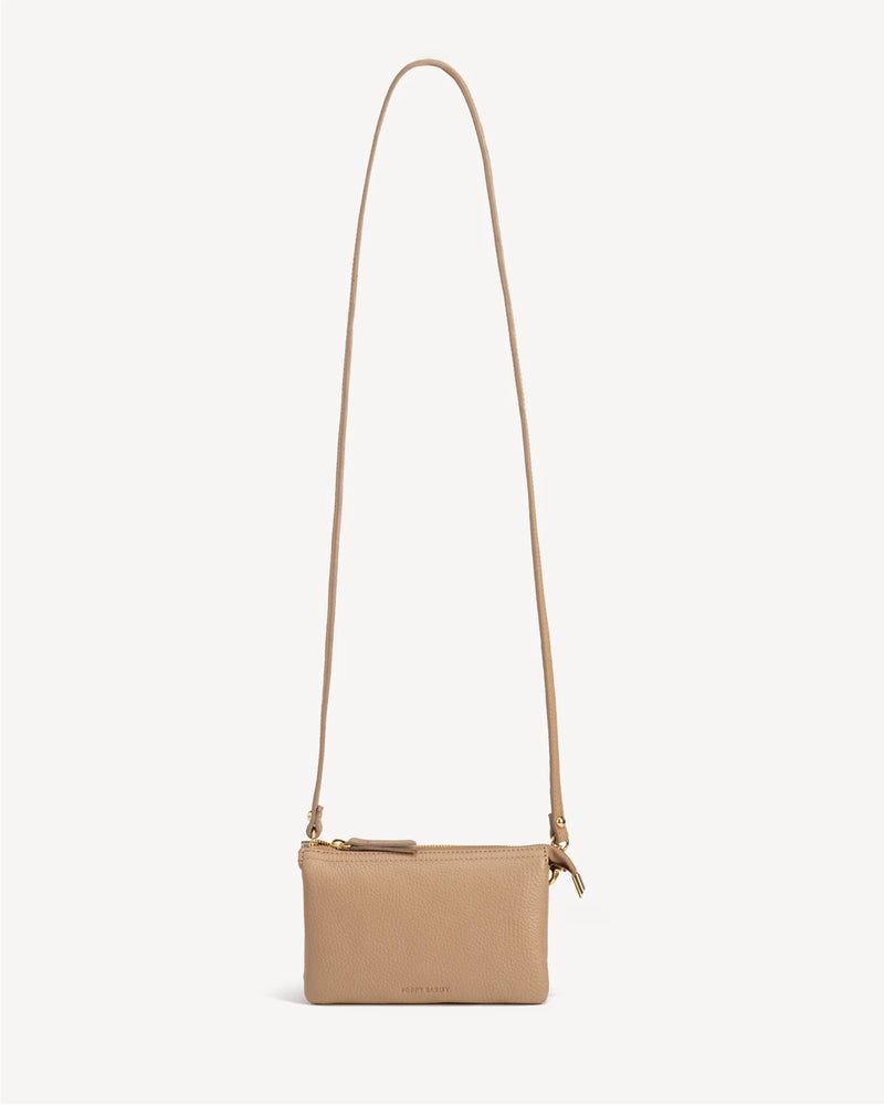 Front view of the pebbled-leather wristlet with a long crossbody strap laid flat. The 3-in-1 Wristlet Biscotti Pebble.